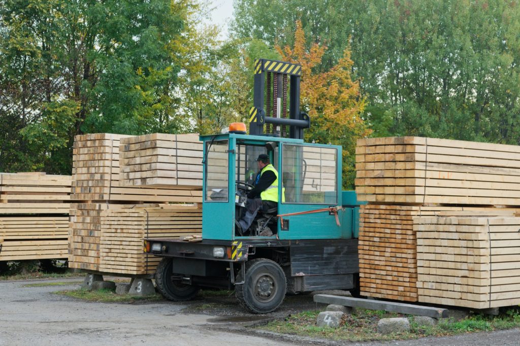 Forklift transports the boards at the plant for woodworking. Woodworking industry